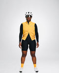 Cycling Out Loud unisex gold cycling vest/gilet, worn on model, side view, women's fit